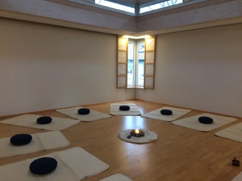 Heller Kursraum mit Meditationskissen im Kreis